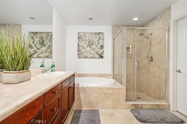 a bathroom with a granite countertop sink a mirror a bathtub and shower