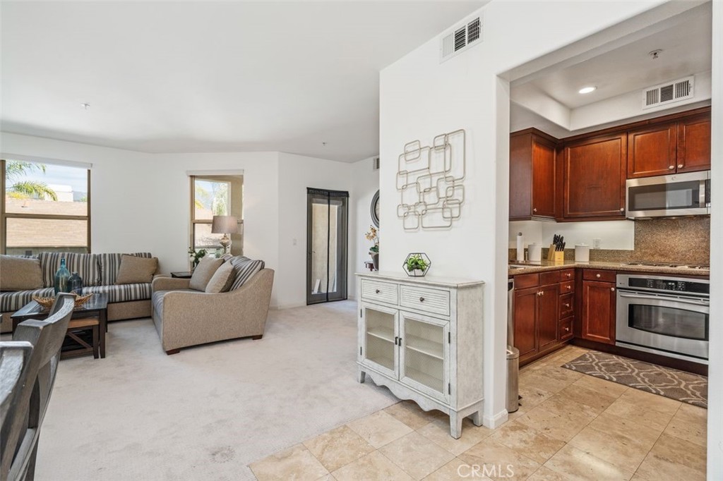 128 North Oak Knoll Avenue, Unit 317 Pasadena, CA 91101 - Photo 2 of 22 a large living room with stainless steel appliances granite countertop a couch and a window