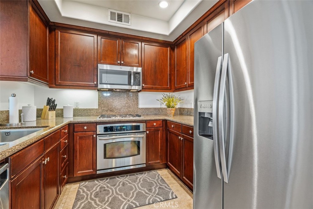 128 North Oak Knoll Avenue, Unit 317 Pasadena, CA 91101 - Photo 7 of 22 a kitchen with stainless steel appliances granite countertop a refrigerator sink and cabinets