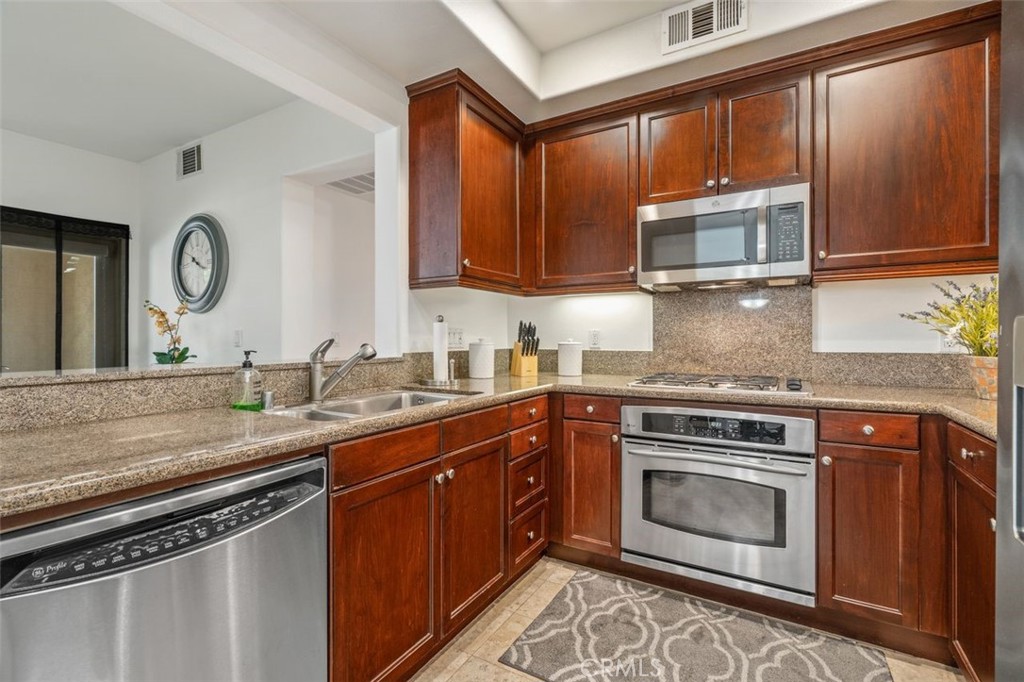 128 North Oak Knoll Avenue, Unit 317 Pasadena, CA 91101 - Photo 8 of 22 a kitchen with stainless steel appliances granite countertop a stove a sink and a microwave