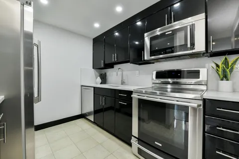a kitchen with stainless steel appliances a stove microwave and cabinets