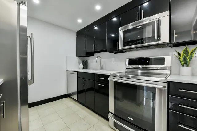 a kitchen with stainless steel appliances a stove microwave and cabinets