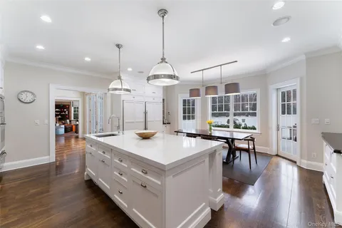 a large kitchen with granite countertop a stove a sink a island and chairs