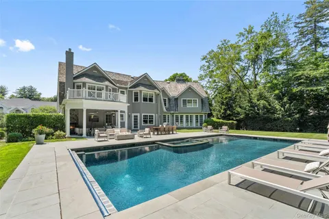 a front view of a house with swimming pool having outdoor seating