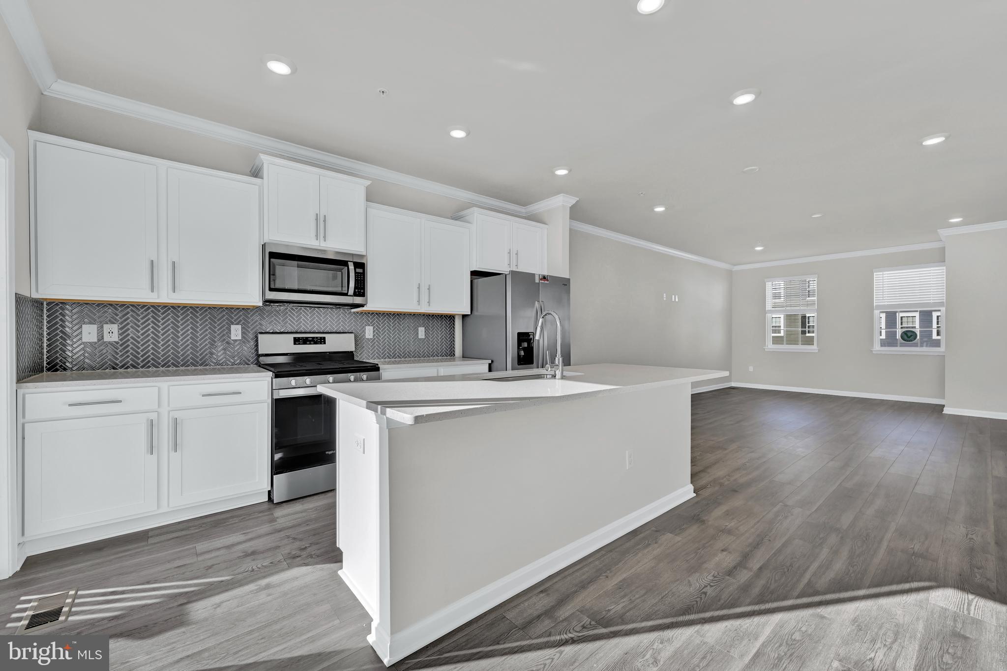 5018 Silver Oak Drive Rosedale, MD 21237 - Photo 12 of 19 a kitchen with stainless steel appliances a sink a stove a microwave a center island and cabinets