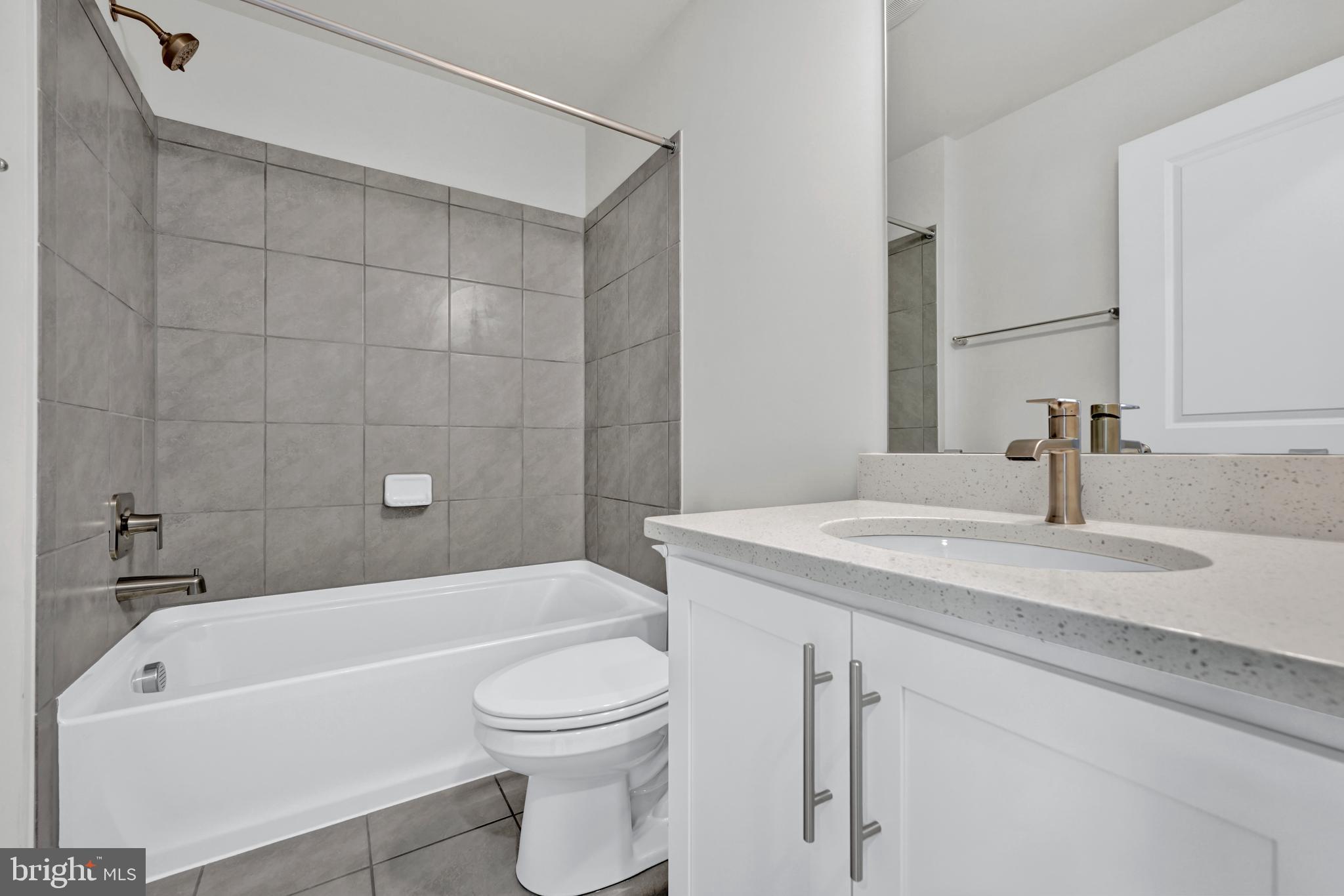 5018 Silver Oak Drive Rosedale, MD 21237 - Photo 16 of 19 a bathroom with a granite countertop bathtub shower sink vanity mirror and toilet