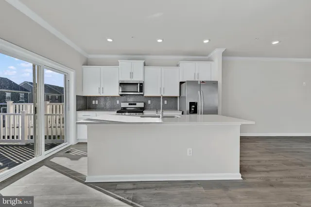 a view of kitchen with stainless steel appliances refrigerator sink microwave and cabinets