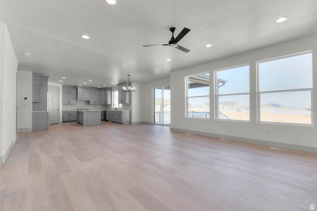 562 West Coyote Rdg Road Grantsville, UT 84029 - Photo 11 of 27 Expansive open-concept living space with light wood-finish flooring, recessed lighting, and a modern ceiling fan