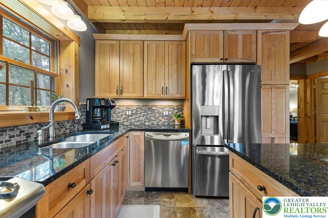 207 West Douglasville Road Nazareth, PA 18064 - Photo 33 of 73 a kitchen with stainless steel appliances granite countertop a refrigerator a stove and a sink with wooden cabinets