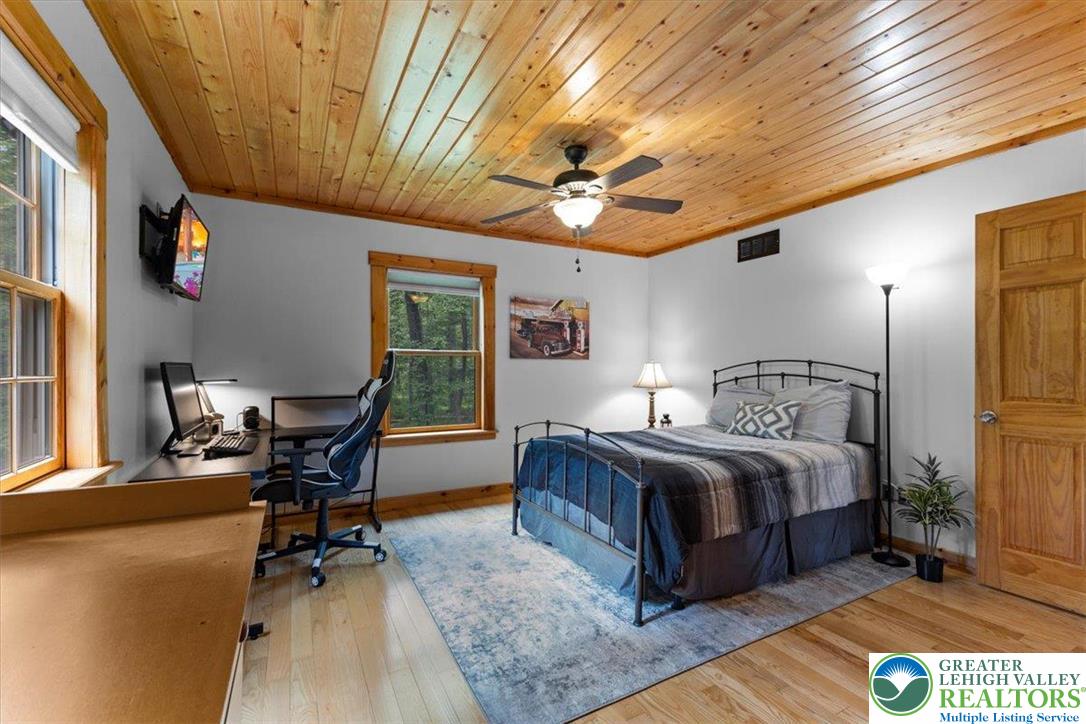 207 West Douglasville Road Nazareth, PA 18064 - Photo 61 of 73 a spacious bedroom with a bed a desk and chair with wooden floor