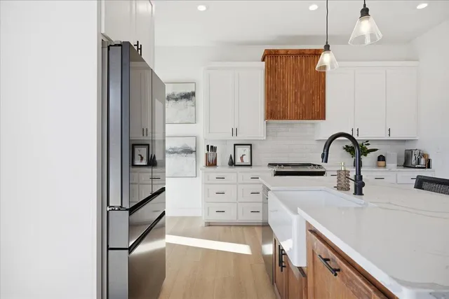 a kitchen with stainless steel appliances a sink cabinets and a refrigerator