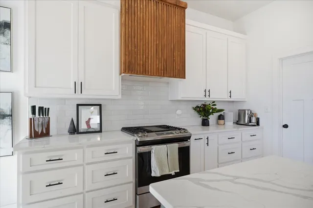 a kitchen with white cabinets and appliances