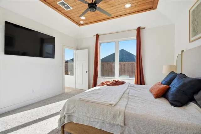 a bedroom with a large bed and a flat screen tv