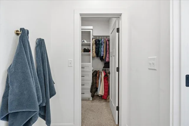 a view of walk in closet with clothes and shoes