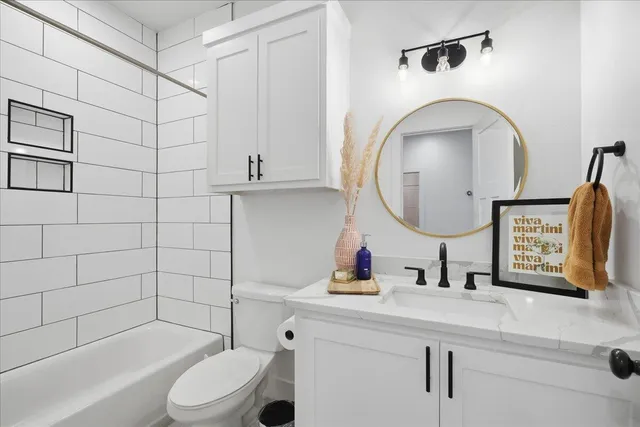 a bathroom with a toilet a sink a mirror and shower