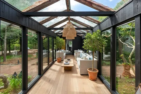 a view of a patio with table and chairs potted plants with floor to ceiling window