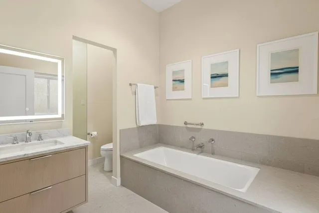a bathroom with a tub sink and mirror