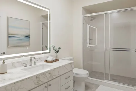 a bathroom with a granite countertop sink toilet and shower