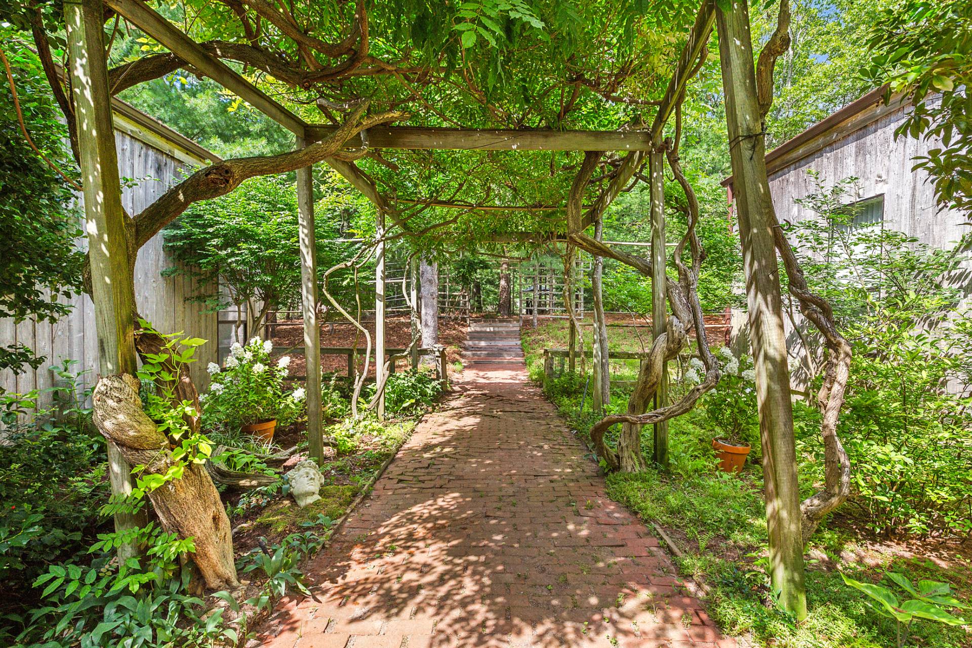 36 Edwards Hole Road East Hampton, NY 11937 - Photo 18 of 23 a view of a pathway of a yard with plants and large trees