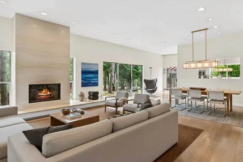 a living room with furniture fireplace and a large window