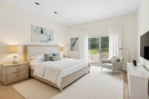 a bedroom with a bed and large window