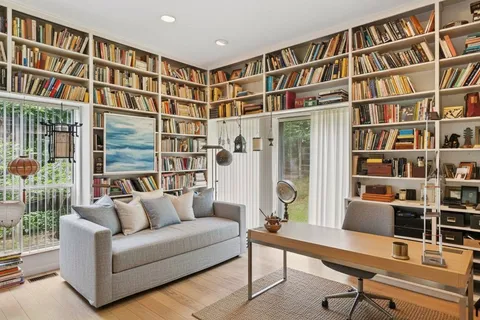 a living room with furniture and a book shelf