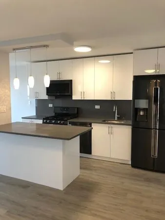 a kitchen with stainless steel appliances granite countertop a stove a sink and a refrigerator