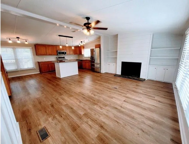a view of a kitchen with cabinets and wooden floor