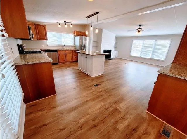 a open kitchen with stainless steel appliances granite countertop a stove and a refrigerator