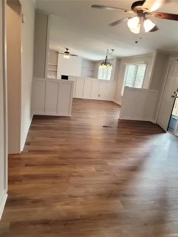 a view of a kitchen with wooden floor and a ceiling fan