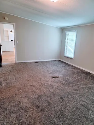 a view of a big room with windows and chandelier fan