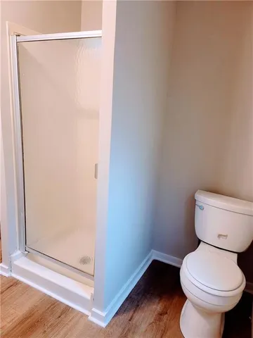 a white toilet sitting next to a shower