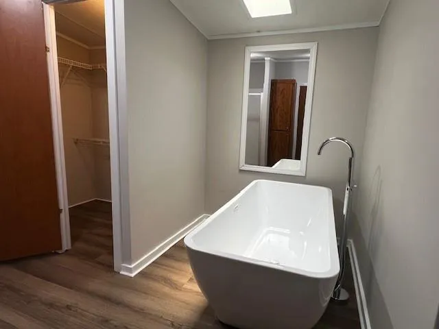 a room with wooden floor and a mirror