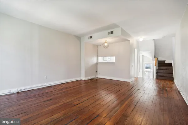 a view of empty room with wooden floor