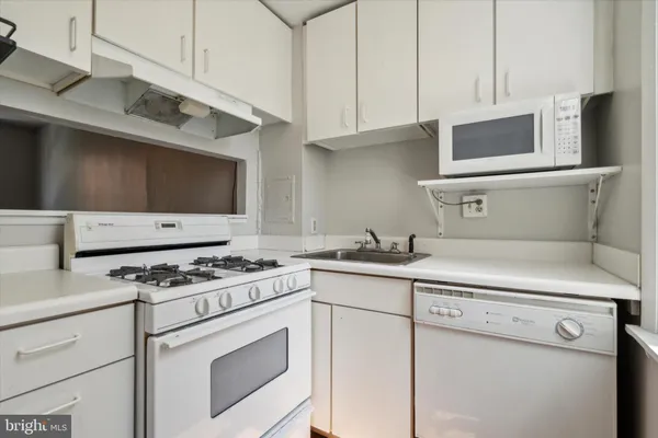 a kitchen with stainless steel appliances a sink a stove and microwave