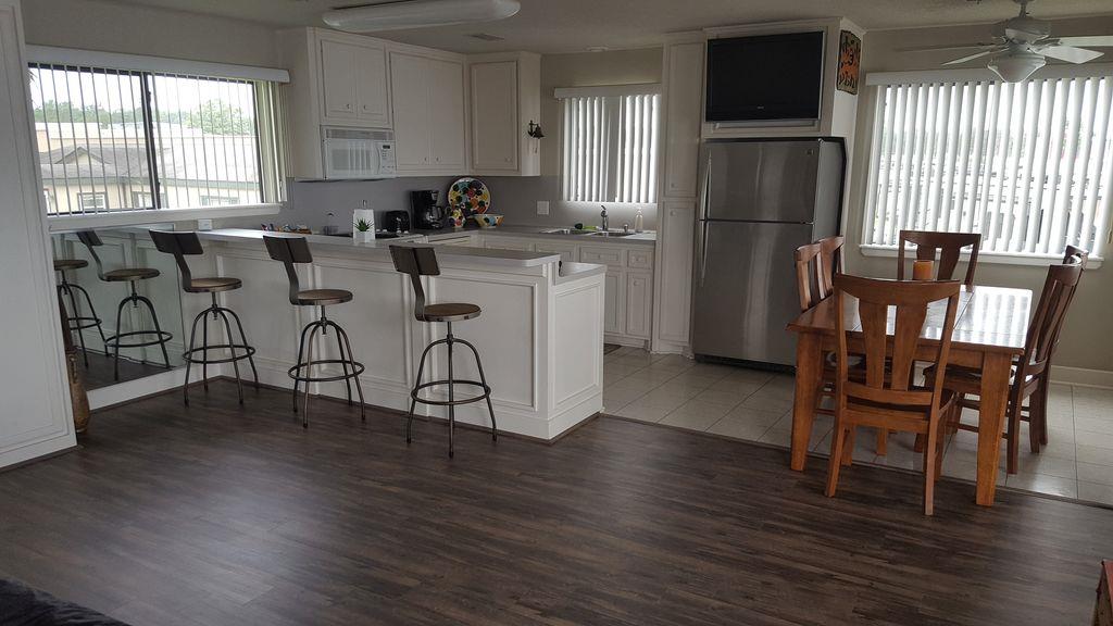 844 Beach Walk Boulevard Conroe, TX 77304 - Photo 10 of 20 a kitchen with stainless steel appliances granite countertop a dining table chairs refrigerator sink and cabinets