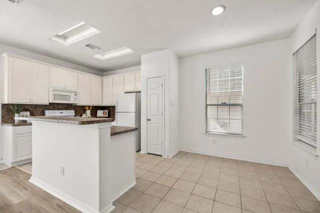 a kitchen with cabinets and window