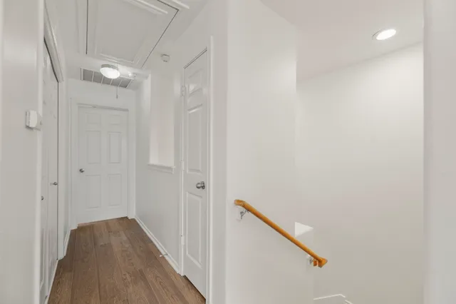 a view of a hallway with wooden floor and staircase