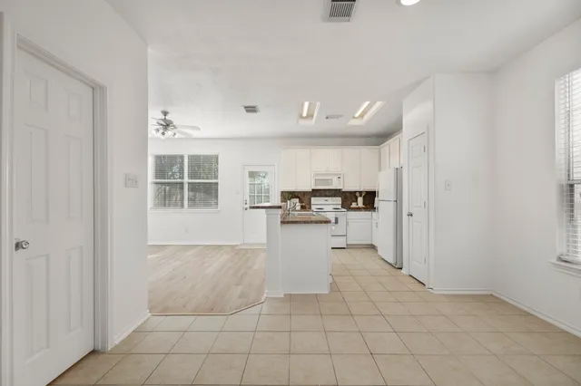 a kitchen with white cabinets and stainless steel appliances