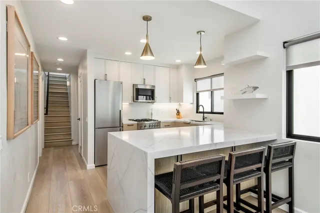 a kitchen with kitchen island white cabinets and stainless steel appliances