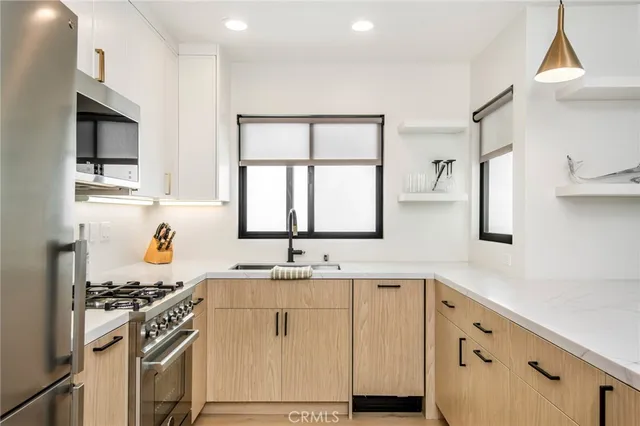 a kitchen with granite countertop a sink cabinets stainless steel appliances and a window