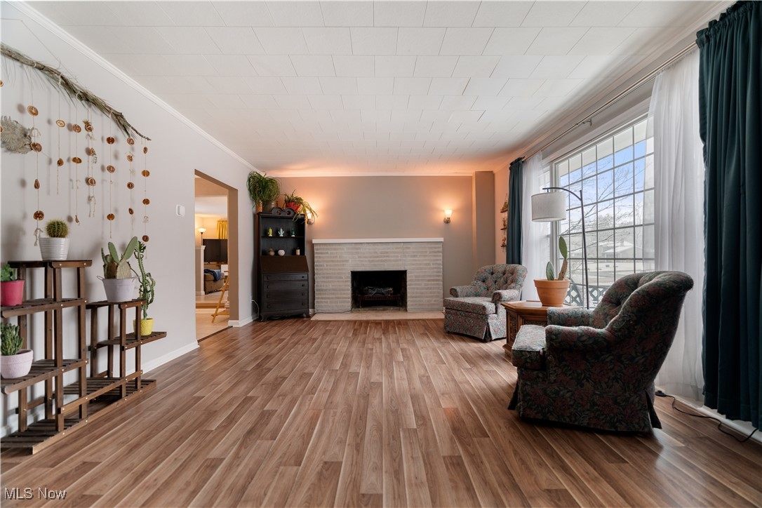 6003 Keller Road Akron, OH 44319 - Photo 2 of 17 Family room featuring crown molding, a fireplace, and hardwood / wood-style flooring