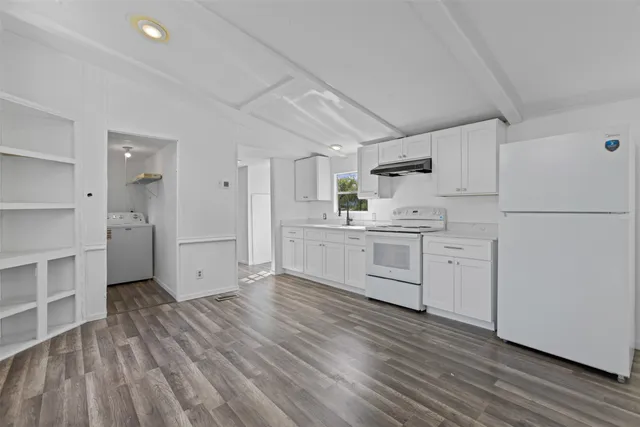 a kitchen with white cabinets and white appliances