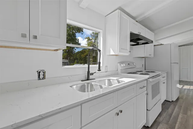 a kitchen with stainless steel appliances granite countertop a sink and a stove