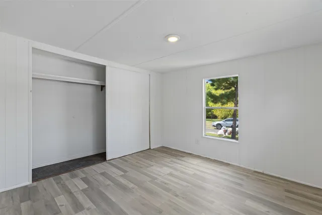 an empty room with windows and closet