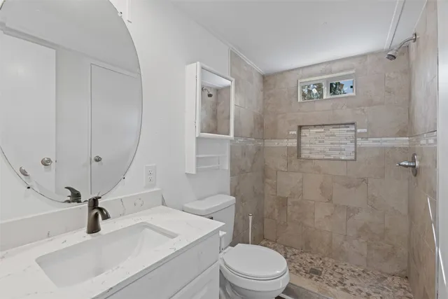 a bathroom with a sink a toilet and shower