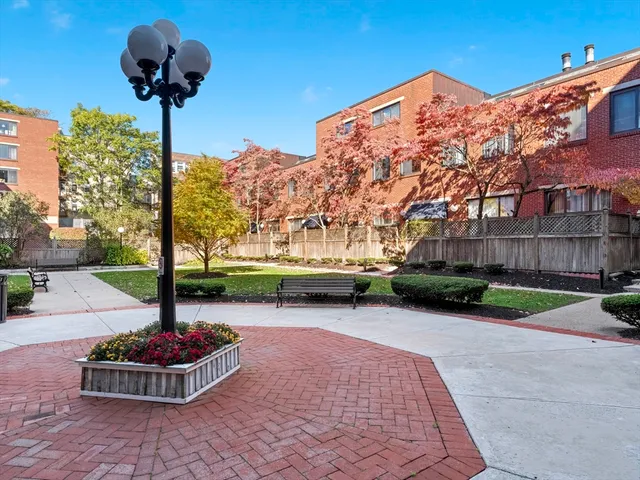 a front view of a house with garden and trees