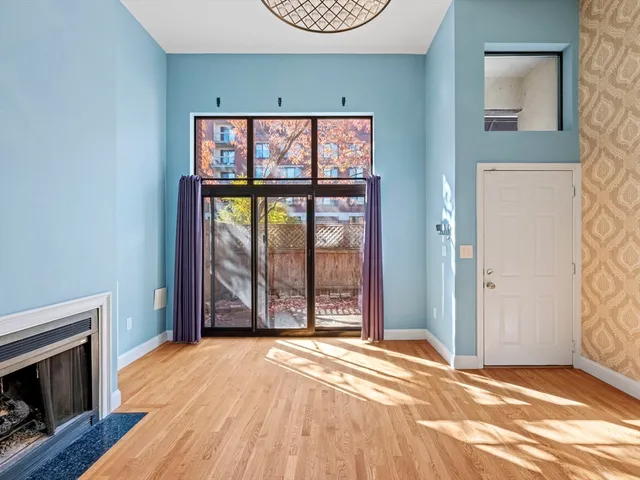 a view of an empty room with a fireplace and a window