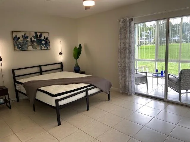 a bedroom with a bed a table and a painting on the wall