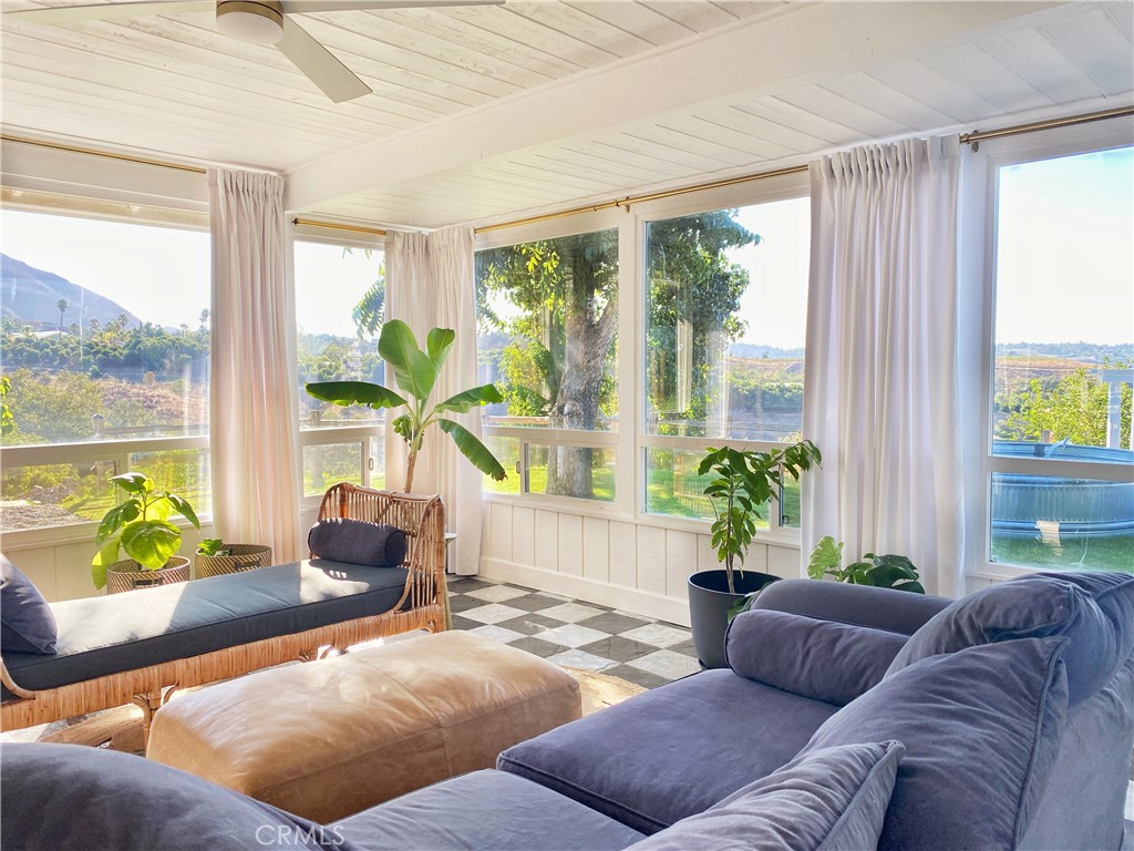 a living room with furniture and floor to ceiling windows